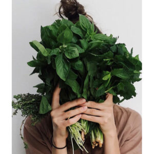 Person holding up healthy, nutritious food in front of their face